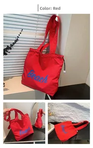 Detalle del bolso tote rojo con letras Beach en azul y cordones laterales