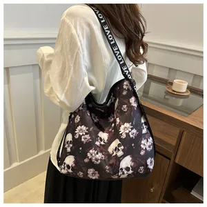 Close-up of black nylon crossbody bag with skull and flower print and LOVE strap