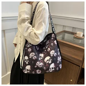Detail of crossbody bag featuring skull floral print and wide strap with LOVE text