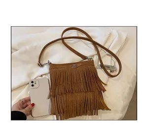 Size comparison of brown matte fringe crossbody bag next to a white smartphone
