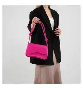 Detail einer magentafarbenen Tasche mit Knotendetails am Schultergurt