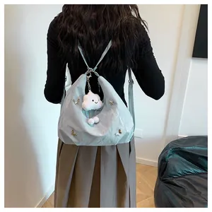 Détail du sac à bandoulière plissé bleu clair avec papillon en métal et charm nuage