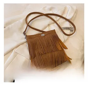 Detailed macro view of vintage brown suede tassel bag with elegant metal buckle decoration