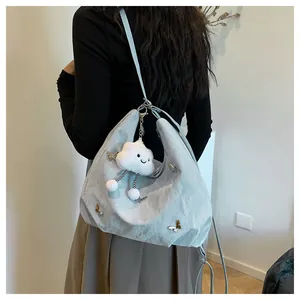 Détail du sac hobo bleu clair avec breloques papillons et pendentif nuage doux