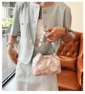 Detail der rosa bestickten Seiden-Beuteltasche mit Perlengriff und Schmetterlingsmuster