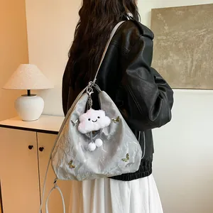 Sac hobo gris avec motifs papillons et breloque nuage porté à l'épaule pour femme