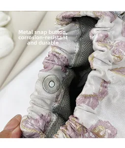 Detail des silbernen Magnetverschlusses auf rosa Jacquardgewebe mit Stickerei-Textur