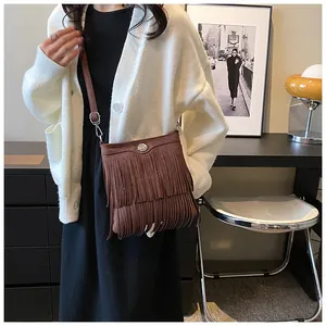 Detailed view of brown fringe crossbody bag with retro bohemian suede texture and metal buckle