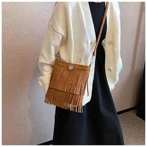 Close-up of brown suede tassel crossbody bag featuring double-layered fringe detail