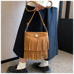Detailed shot of brown suede fringe shoulder bag with silver metal ring and strap