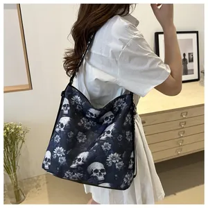 Detailed side view of black crossbody bag with skull and flower print on wide strap