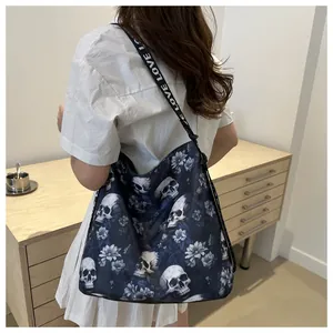 Detail of navy nylon tote bag featuring skull floral print and LOVE lettered shoulder strap