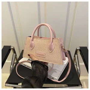 Detailed view of pink woven handbag with leather straps and Fashion & Bags brand tag