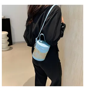 Close-up of light blue bucket bag with artistic gold botanical pattern on a model