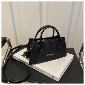 Close-up of black handbag with fine horizontal texture and metallic logo detail