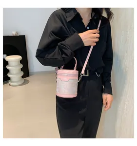 Detail of pink cylindrical bucket bag with butterfly print and silver hardware details