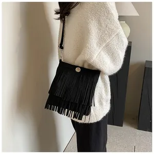 Detail of black fringe crossbody bag in matte faux suede with three layers of tassels