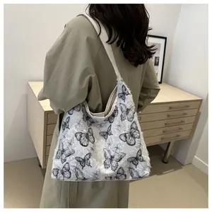 Vue arrière d'un sac cabas en toile blanche avec broderies de papillons en dentelle noire