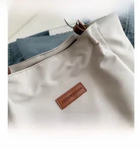Detailed close-up of a stylish tote bag showing its fabric texture and leather label