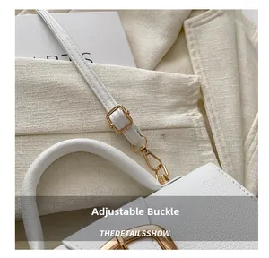 Detail of adjustable white lychee leather shoulder strap with golden metal buckle