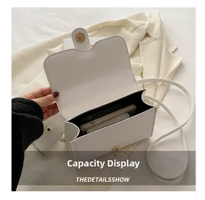 Interior view of white pebble leather crossbody bag showing capacity for a smartphone