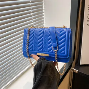 Royal blue quilted shoulder bag with gold chain strap and elegant chevron stitching