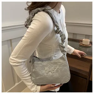 Silver metallic cloud bag with butterfly detail and ruched strap shown on model
