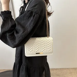 Chic cream quilted crossbody bag with chevron stitching and gold chain strap