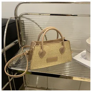 Detail showing woven texture and leather trim of the stylish straw handbag on a shelf