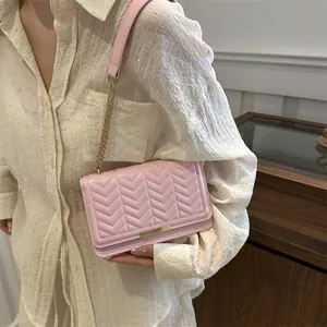 Chic pink quilted PU leather crossbody bag with gold chain strap and metal bar detail