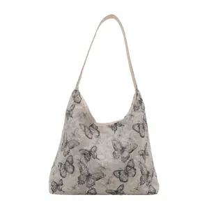 Sac bandoulière en toile blanc cassé avec broderie papillon noire et texture dentelle