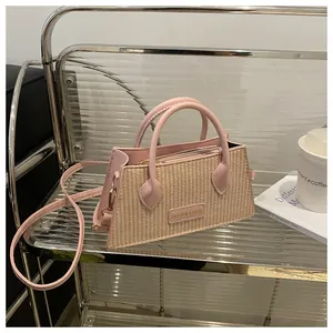 Detailed view of a pink and beige woven handbag on a stylish shelf with coffee