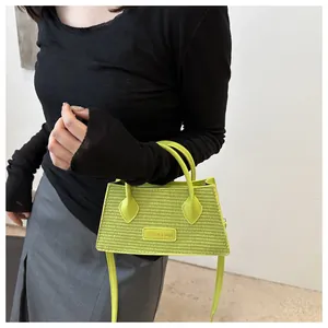 Detail of neon green woven handbag with top handles and fashion logo patch