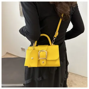 Detail of yellow handbag with gold buckle and matching mini coin purse attachment