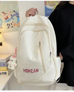 Detail of off-white backpack with HOKEAM logo, side pocket and plush bear charm