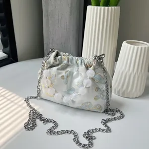 Detailaufnahme der bestickten Schmetterlingsbeuteltasche mit Perlengriff und Silberkette