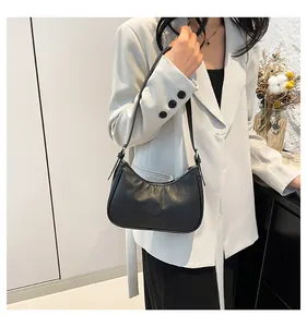 Classic black quilted crossbody bag styled with a light gray blazer in a minimalist room