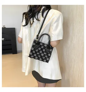 Détail du mini sac cabas en tweed à carreaux montrant la texture des franges