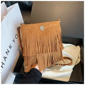 Close-up of caramel suede fringe crossbody bag in a premium black gift box set