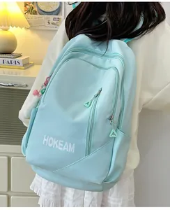 Detailed side view of light blue waterproof backpack with HOKEAM logo and cute pink pendant