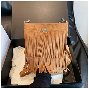 Detail view of brown suede fringe crossbody bag inside a premium gift box packaging