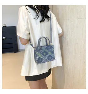 Détail du sac à main en jean bleu avec étoiles vertes et finitions effilochées tendance