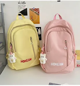 Detail of waterproof backpacks with vertical zippers and cute white bear charms
