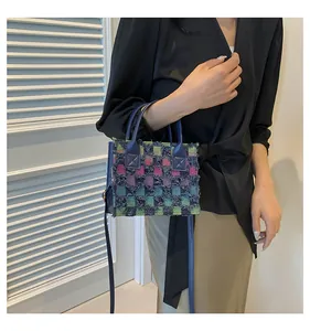 Détail du petit sac cabas en tweed à carreaux avec franges et bandoulière bleue
