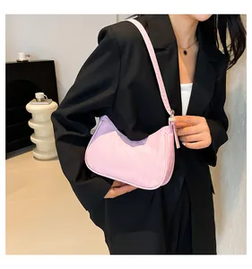 Detail view of pink quilted faux leather shoulder bag worn by model in casual style