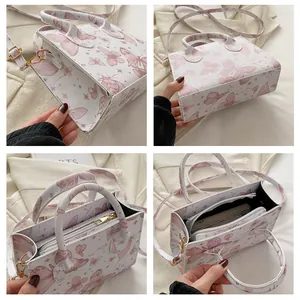 Detailed interior of a white tote bag with pink butterfly prints and gold metal hardware