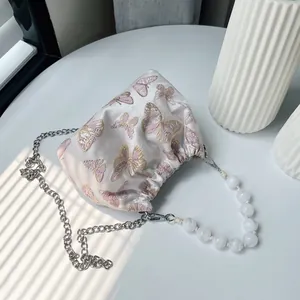 Detail der Seidenbeuteltasche mit rosa Schmetterlingsstickerei und Perlen Griff