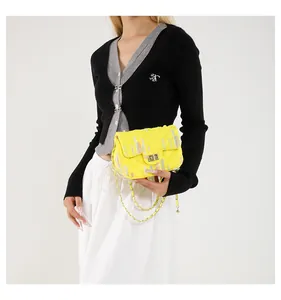 Détail du sac bandoulière jaune matelassé avec fermoir doré et surpiqûres colorées