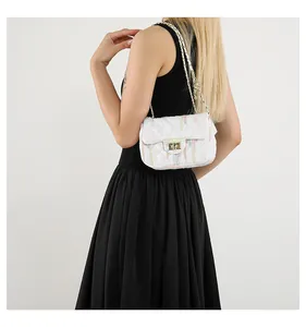 Détail d'un sac bandoulière matelassé blanc avec rayures colorées et chaîne dorée