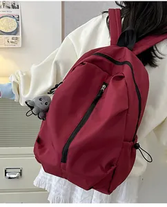 Seitenansicht des weinroten Nylonrucksacks mit vertikalem Reißverschluss und Oktopus-Anhänger